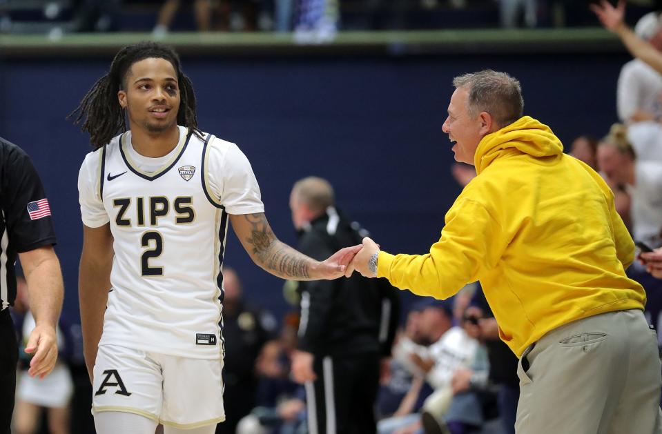 Akron Zips guard Greg Tribble, left, celebrates with fans after making the game-winning free throw in overtime during an NCAA college basketball game against South Dakota State, Monday, Nov. 7, 2022, in Akron, Ohio.