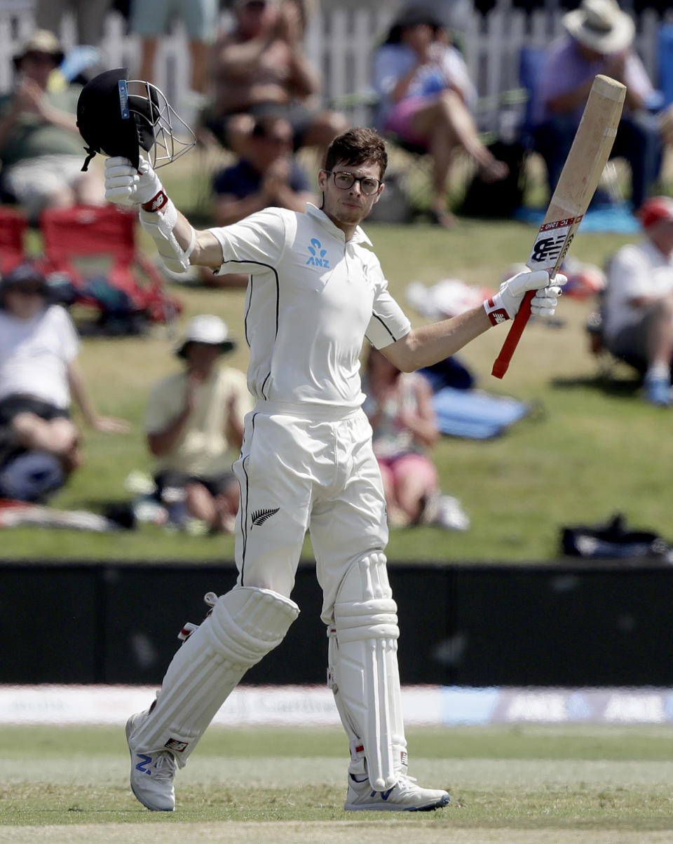 New Zealand's Mitchell Santner celebrates after scoring a century during play on day four of the first cricket test between England and New Zealand at Bay Oval in Mount Maunganui, New Zealand, Sunday, Nov. 24, 2019. (AP Photo/Mark Baker)