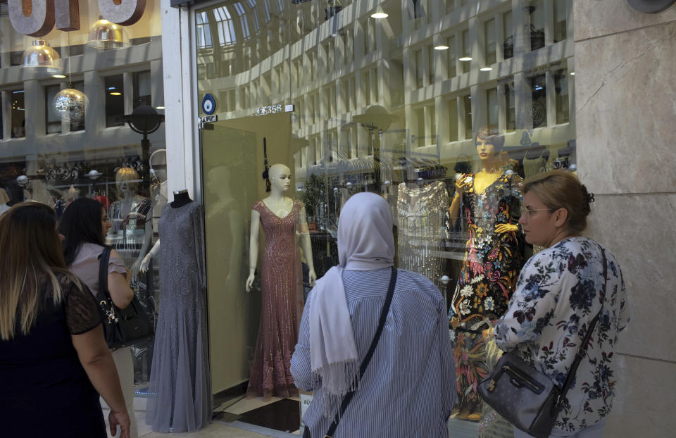 Women look at shop windows in a shopping mall in Ankara, Turkey, Wednesday, Aug. 15, 2018. Turkey announced increased duties on US products, including cars, tobacco and alcohol, on Wednesday in retaliation for U.S. sanctions and tariffs on Turkey in an on-going feud over the detention of an American pastor.(AP Photo/Burhan Ozbilici)