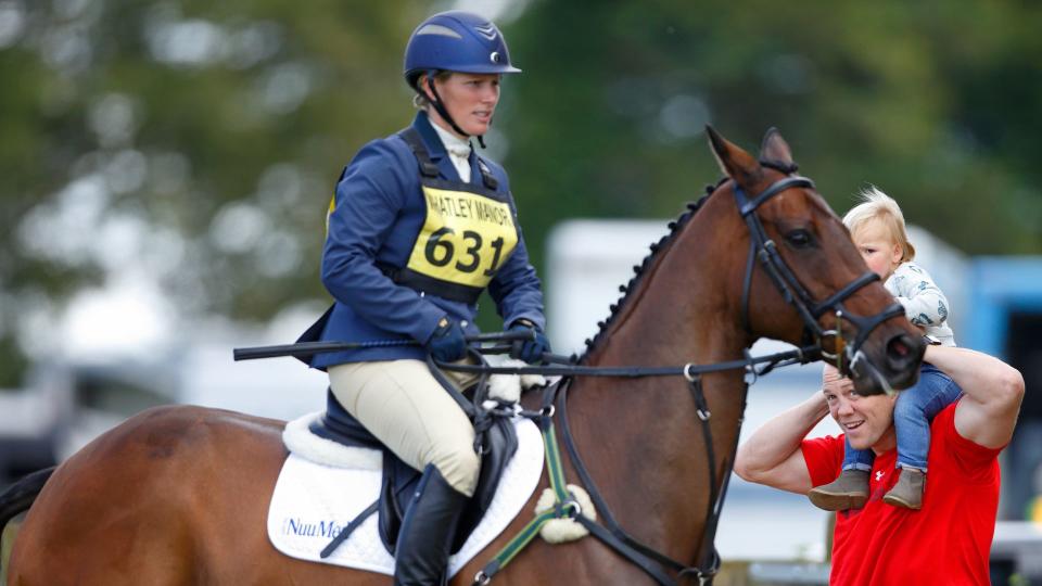 Zara Tindall riding a horse while Mike Tindall watches on