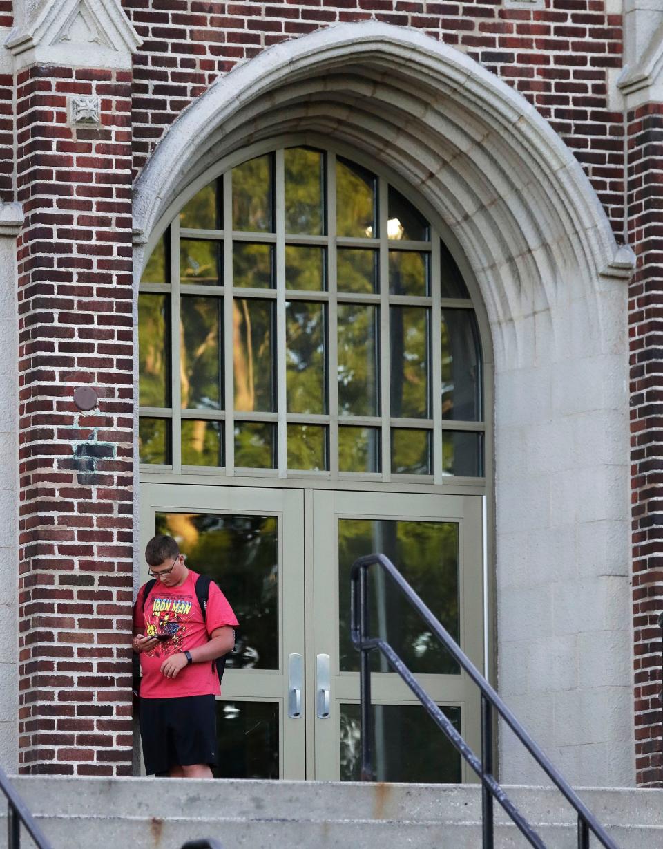 Manitowoc Lincoln sophomore Caleb Meyer, 15, waits by the entrance of the school on the first day of classes, Tuesday, August 30, 2022, in Manitowoc, Wis.