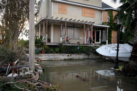 Residents sit on their front porch watching water reside after Hurricane Irma in Everglades City, Florida, U.S., September 11, 2017. REUTERS/Bryan Woolston