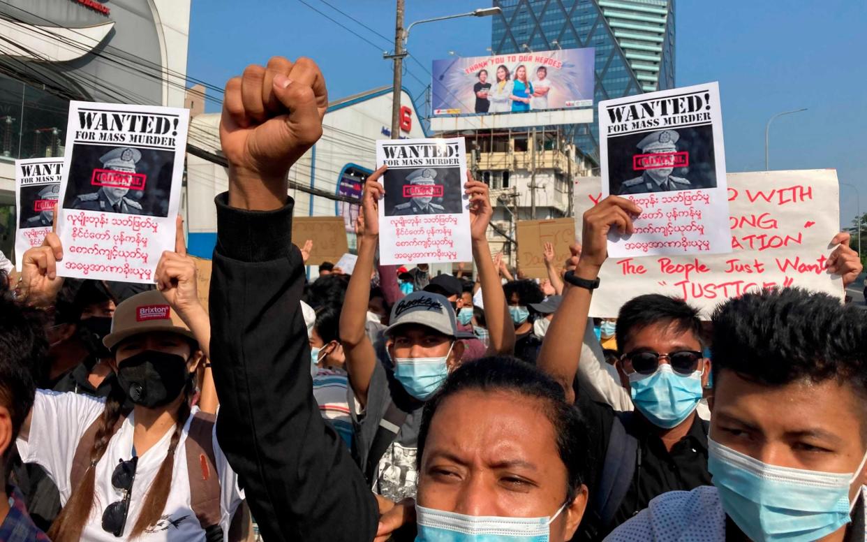 Protesters hold up Wanted posters with an image of Myanmar's Commander-in-Chief Senior Gen. Min Aung Hlaing, as they march in Yangon - AP