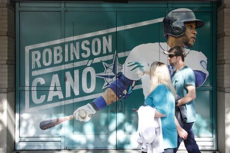 FILE PHOTO: May 15, 2018; Seattle, WA, USA; Seattle Mariners fans walk past an oversized photo of second baseman Robinson Cano (22) before a game against the Texas Rangers at Safeco Field. Mandatory Credit: Joe Nicholson-USA TODAY Sports