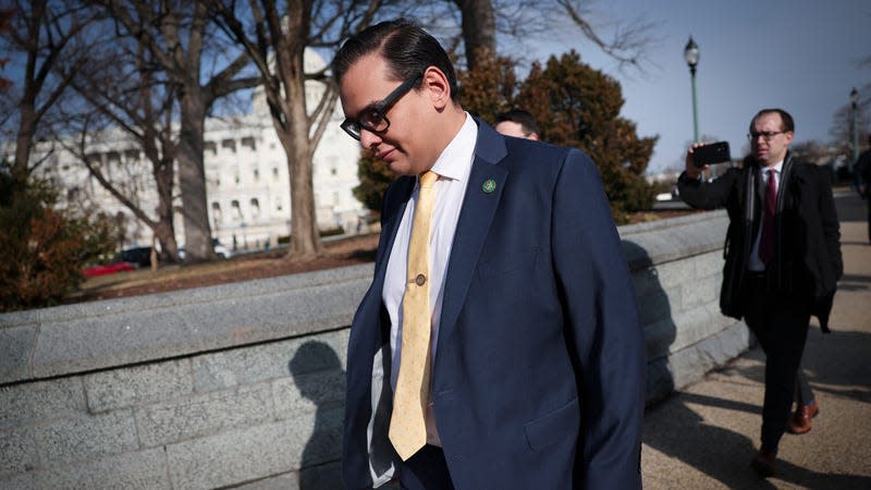 George Santos walking down the street in Washington with his head down.