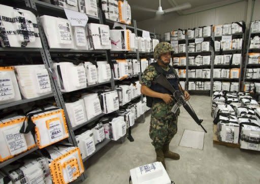 A Mexican marine stands guard inside the Federal Electoral Institute (IFE) building during the counting of votes from the presidential election in Acapulco, Guerrero state, Mexico. Mexico's national election authority announced a recount of ballots cast at more than half of the polling stations in the country's weekend presidential election in which Enrique Pena Nieto claimed victory