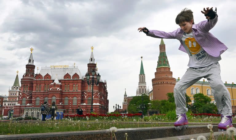 Niño ruso con sus rollersmpatina frente al Kremlin en Moscú.