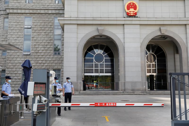 Police officers stand guard at an entrance to Beijing No. 2 Intermediate People's Court