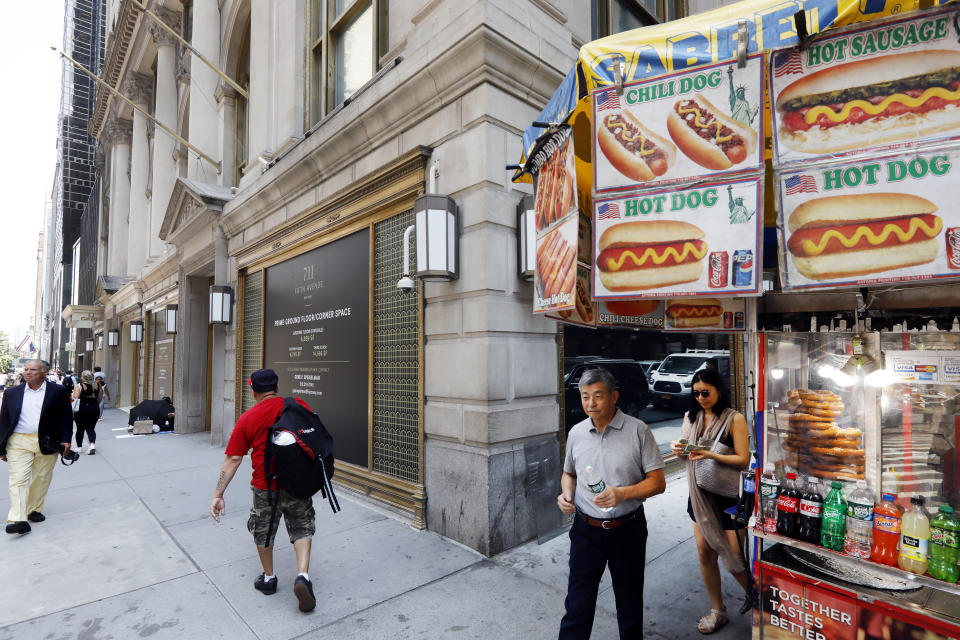 In this July 30, 2019, photo people pass the former Polo Ralph Lauren store, on New York's Fifth Avenue. Over the last year or so, Gap, Tommy Hilfiger, Lord & Taylor and Polo Ralph Lauren have closed their flagship stores on Manhattan's Fifth Avenue. (AP Photo/Richard Drew)