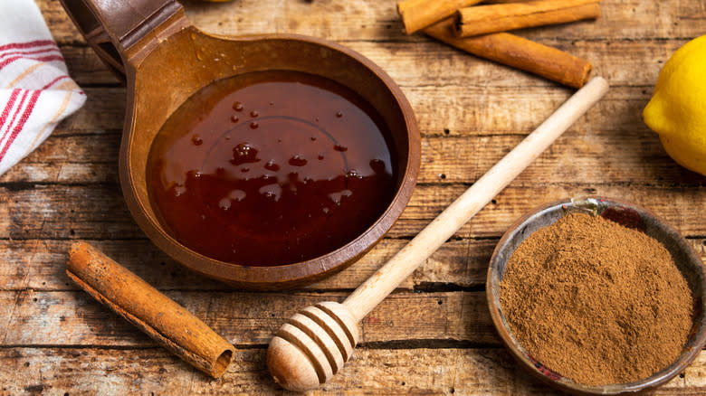 Honey and cinnamon on wooden board