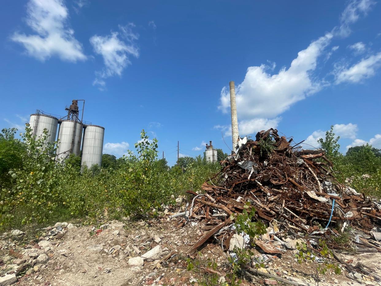 A heap of twisted metal sits among overgrown vegetation at the former Drewrys Brewery site at 1408 Elwood Ave. on Aug. 18, 2023. A concrete smokestack that rises more than 150 feet on the site's north side is likely to be all that's left standing.