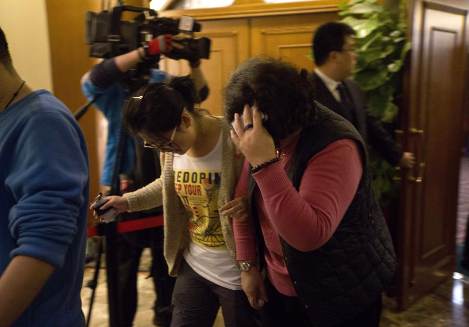 Chinese relatives of passengers aboard a missing Malaysia Airlines plane walk out from a hotel room after attending a briefing by Malaysia Airlines in Beijing, China Sunday, March 16, 2014. Attention focused Sunday on the pilots of the missing Malaysia Airlines flight after the country's leader announced findings so far that suggest someone with intimate knowledge of the Boeing 777's cockpit seized control of the plane and sent it off-course. (AP Photo/Andy Wong)