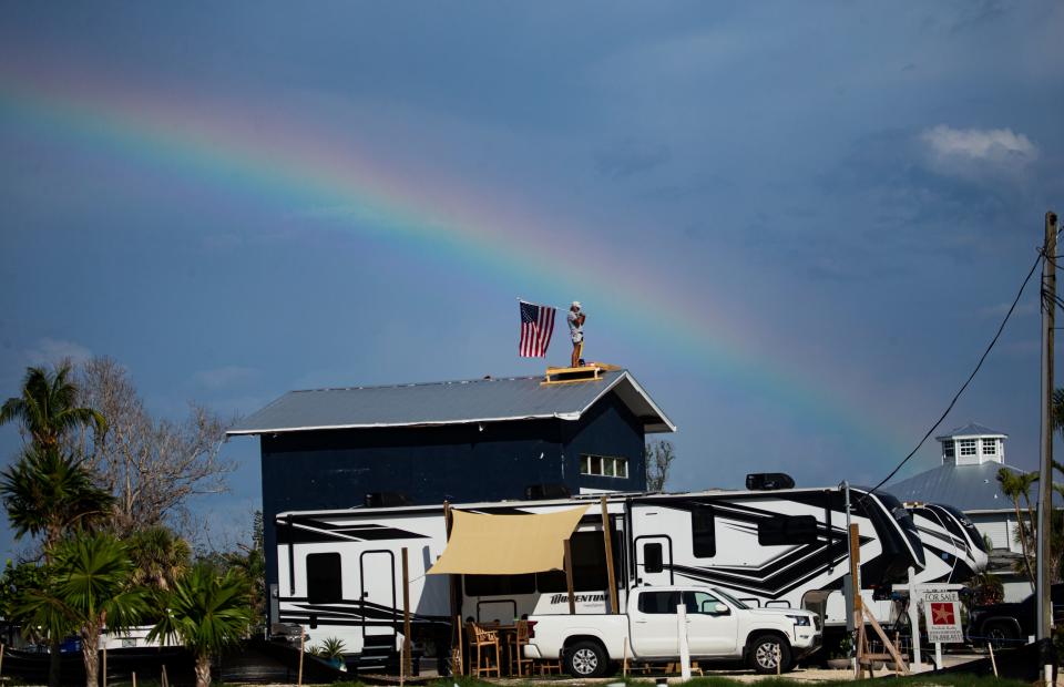 With a rainbow in the background, Rick Loughrey, Fort Myers Beach resident and Hurricane Ian survivor, stands on the roof of his garage minutes before ending his protest Monday, August 7, 2023. Loughrey spent six days on the roof hoping to get answers regarding the fate of his garage with recent interpretations of FEMA regulations by the Town of Fort Myers Beach. The protest ended without answers.