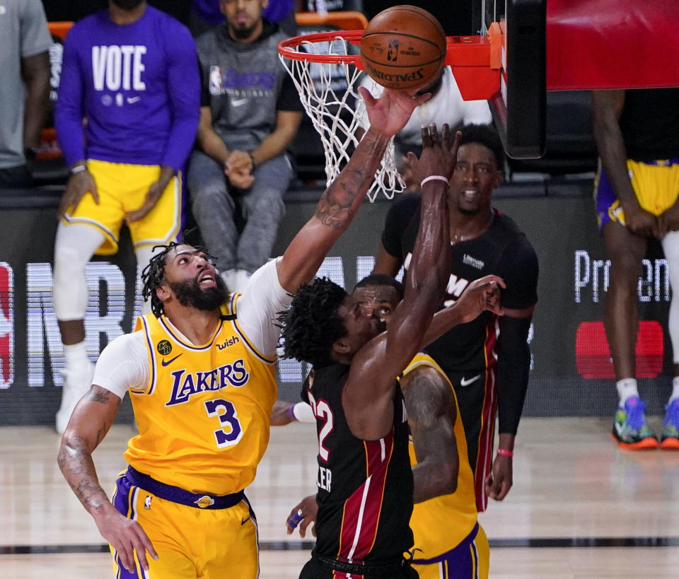 Lakers forward Anthony Davis blocks a shot by Heat forward Jimmy Butler late in the second half in Game 4 Tuesday night. (AP Photo/Mark J. Terrill)