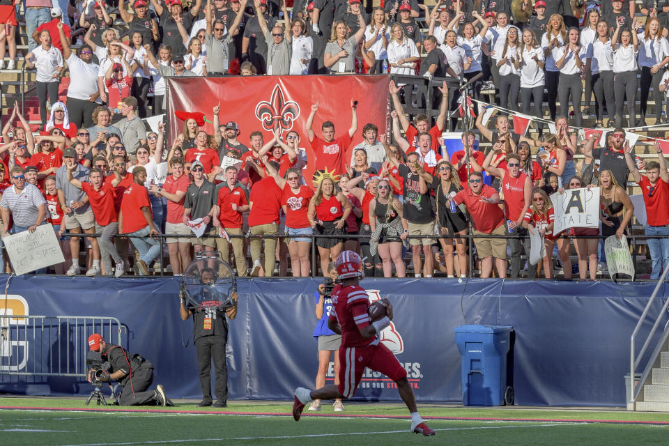 Louisiana-Lafayette quarterback Levi Lewis (1) looks at the crowd as he scores a touchdown during the first half of the Sun Belt Conference championship NCAA college football game against Appalachian State in Lafayette, La., Saturday, Dec. 4, 2021. (AP Photo/Matthew Hinton)