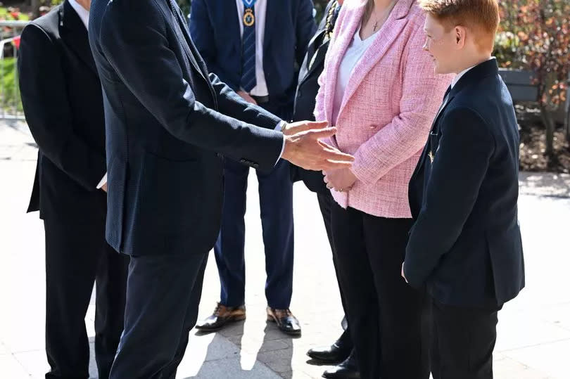 The Prince of Wales speaks with twelve-year-old Freddie Hadley (right), who made the initial invitation to visit the school