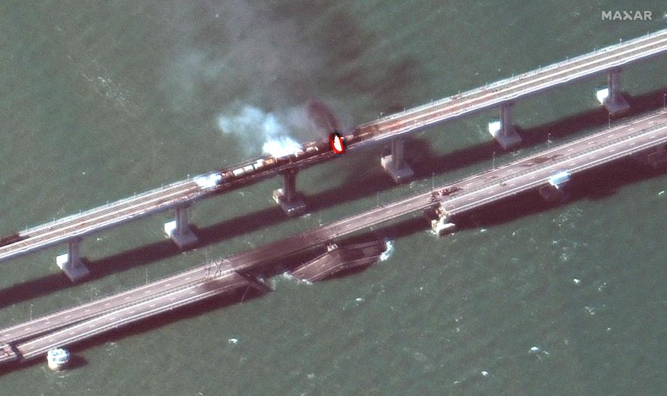 This handout satellite image taken and released by Maxar Technologies on October 8, 2022, shows smoke billowing from a fire on the Crimea Bridge that links Crimea to Russia, after a truck exploded, near Kerch.