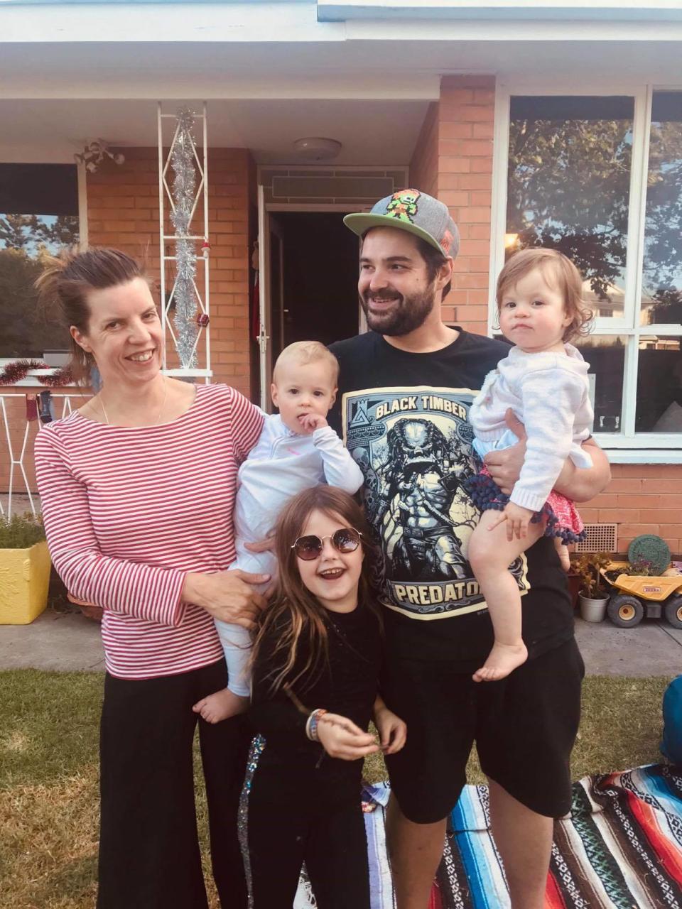 Virginia Carpenter and Adrien are holding their twin daughters and standing with Ms Carpenter's eight-year-old daughter. 