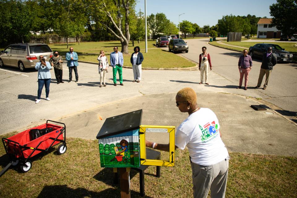 Cynthia Leeks places books into the newly installed little free library at the Murchison Townhouses on Rosemary Street on Friday, April 22, 2022. Leeks, who is president of the Seabrook-Broadell Community Watch, has led ongoing efforts to achieve historical recognition for the area.