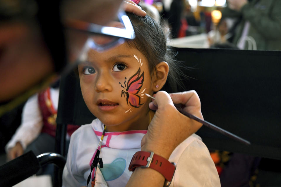 Michelle Alvarado, 4, has her face painted at a Halloween celebration at Denver's Union Station on Thursday, Oct. 28, 2021. Though the pandemic remains a concern, top health officials are largely giving outside activities like trick-or-treating the thumbs up. (AP Photo/Thomas Peipert)