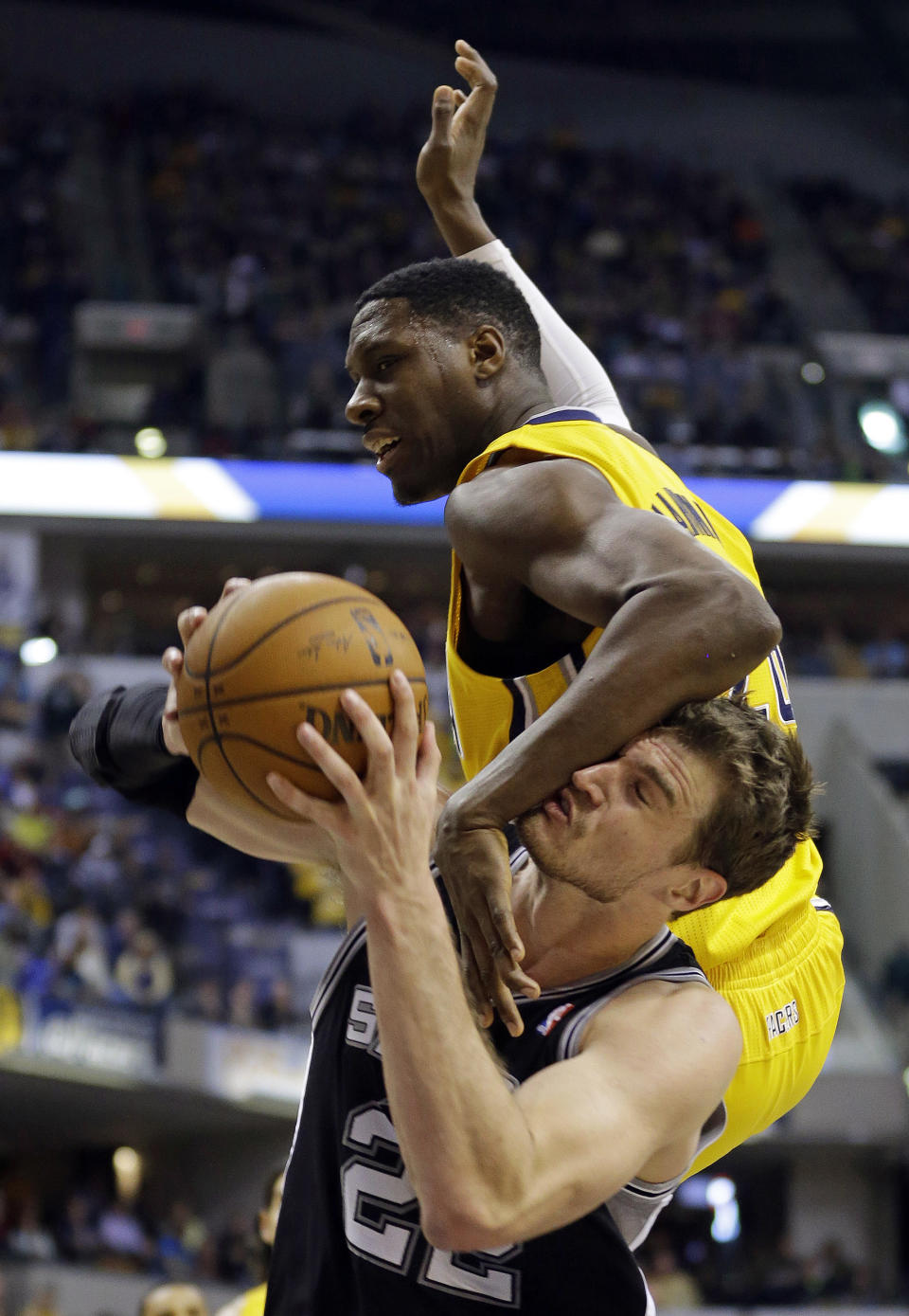 Indiana Pacers center Ian Mahinmi, top, fouls San Antonio Spurs center Tiago Splitter in the second half of an NBA basketball game in Indianapolis, Monday, March 31, 2014. The Spurs defeated the Pacers 103-77. (AP Photo/Michael Conroy)