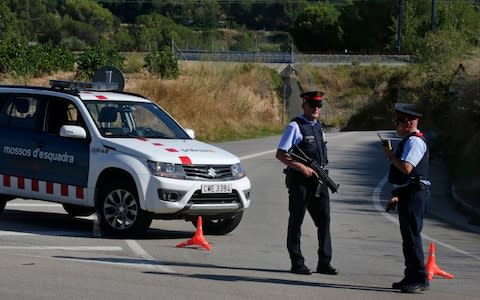 Armed police officers stand guard near Subirats, Spain - Credit: AP Photo/Emilio Morenatti