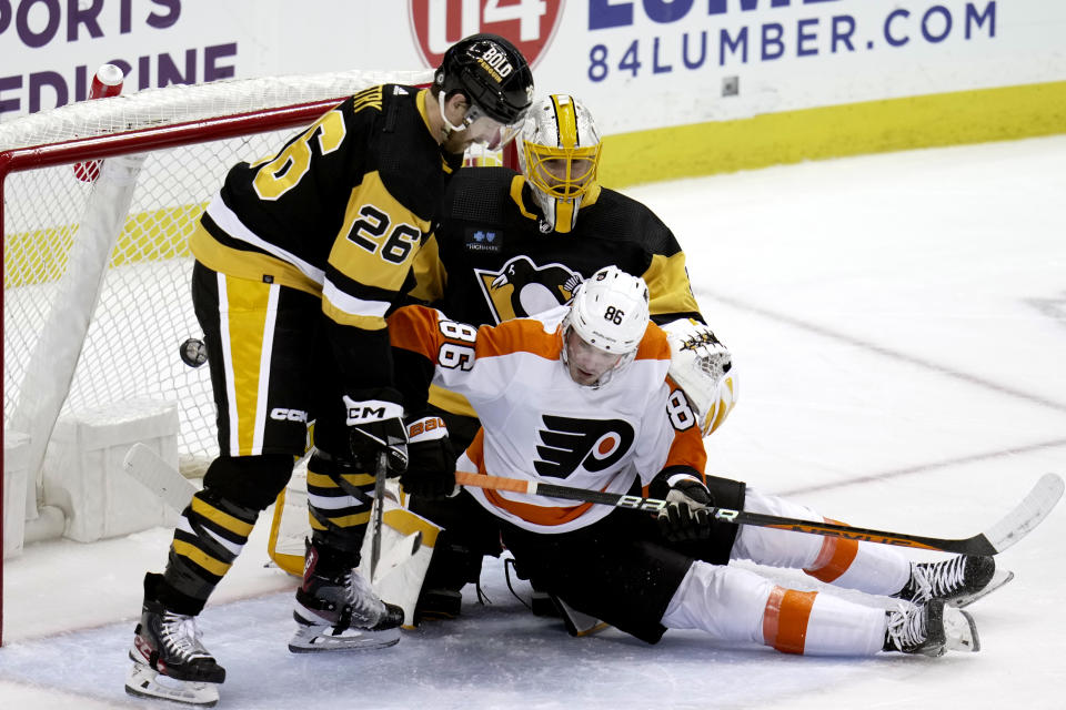 The puck bounces in the back of the net as Philadelphia Flyers' Joel Farabee (86) interferes with Pittsburgh Penguins goaltender Casey DeSmith (1), with Jeff Petry (26) defending during the second period of an NHL hockey game in Pittsburgh, Sunday, April 2, 2023. The play was called a no-goal. (AP Photo/Gene J. Puskar)