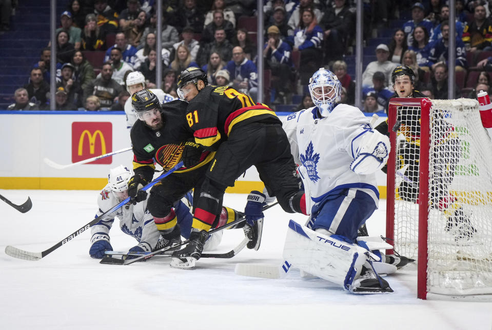 Vancouver Canucks' Conor Garland (8) scores against Toronto Maple Leafs goalie Martin Jones, front right, during the second period of an NHL hockey game in Vancouver, British Columbia, Saturday, Jan. 20, 2024. (Darryl Dyck/The Canadian Press via AP)