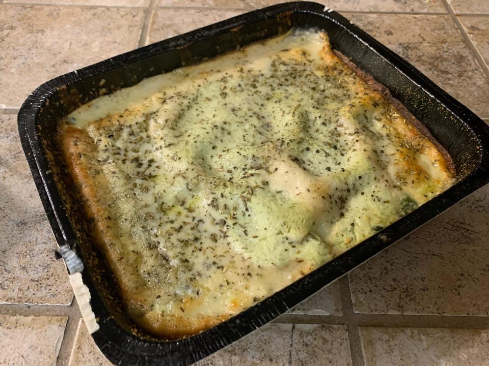 The cooked Trader Joe's florentine lasagna in black container