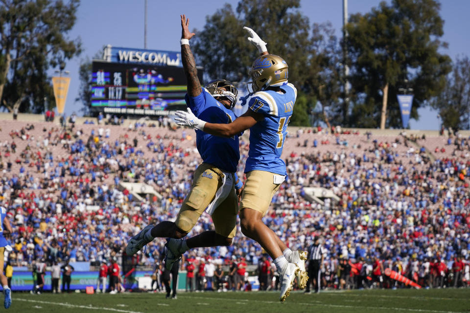UCLA quarterback Dorian Thompson-Robinson (1) and wide receiver Logan Loya (17) celebrate after a touchdown during the second half of an NCAA college football game against Utah in Pasadena, Calif., Saturday, Oct. 8, 2022. UCLA won 42-32. (AP Photo/Ashley Landis)