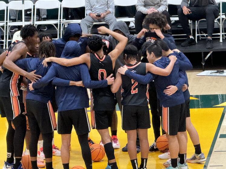 Eastvale Roosevelt players coming together before their 71-66 win over Owyhee at the Classic at Damien.