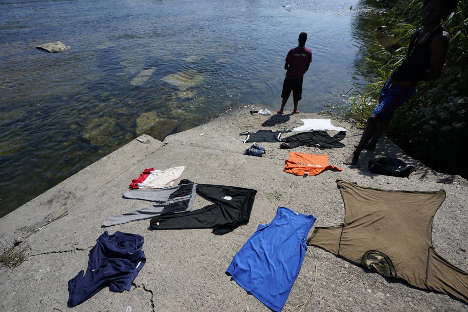 A Haitian migrant uses the Rio Grande to wash clothes after crossing a dam from Mexico to the United States, Friday, Sept. 17, 2021, in Del Rio, Texas. Thousands of Haitian migrants have assembled under and around a bridge in Del Rio presenting the Biden administration with a fresh and immediate challenge as it tries to manage large numbers of asylum-seekers who have been reaching U.S. soil. (AP Photo/Eric Gay)