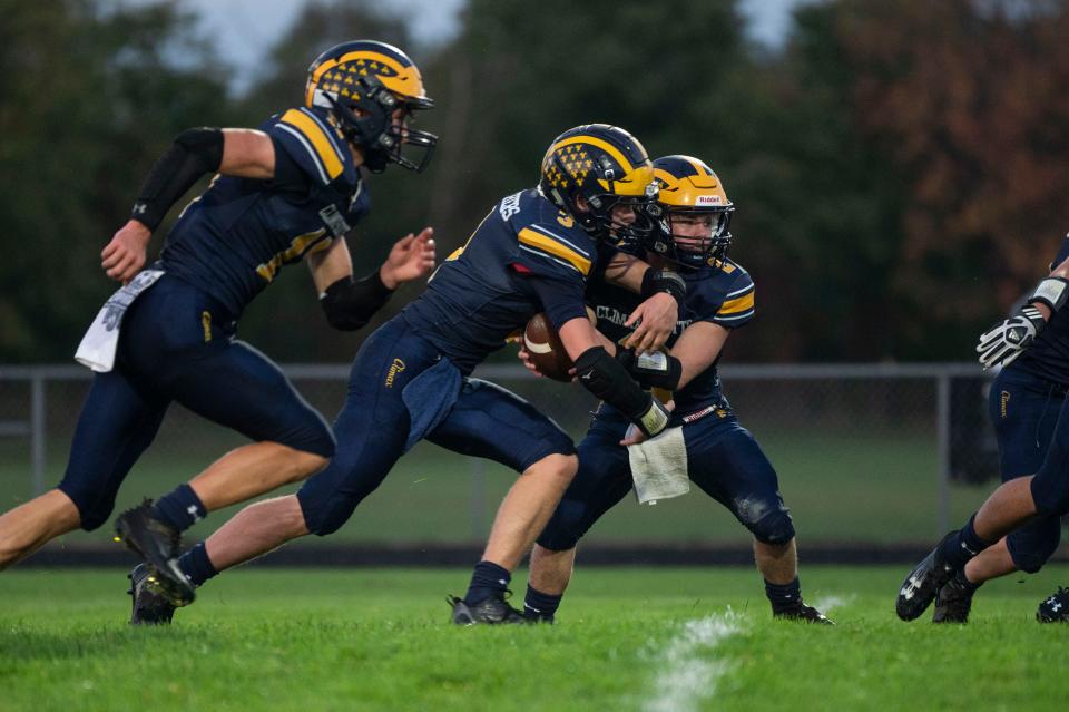 Climax-Scotts quarterback Logan Gilbert hands off to Luke Lawrence during a game against St. Philip at Climax-Scotts High School on Friday, Sept. 29, 2023.