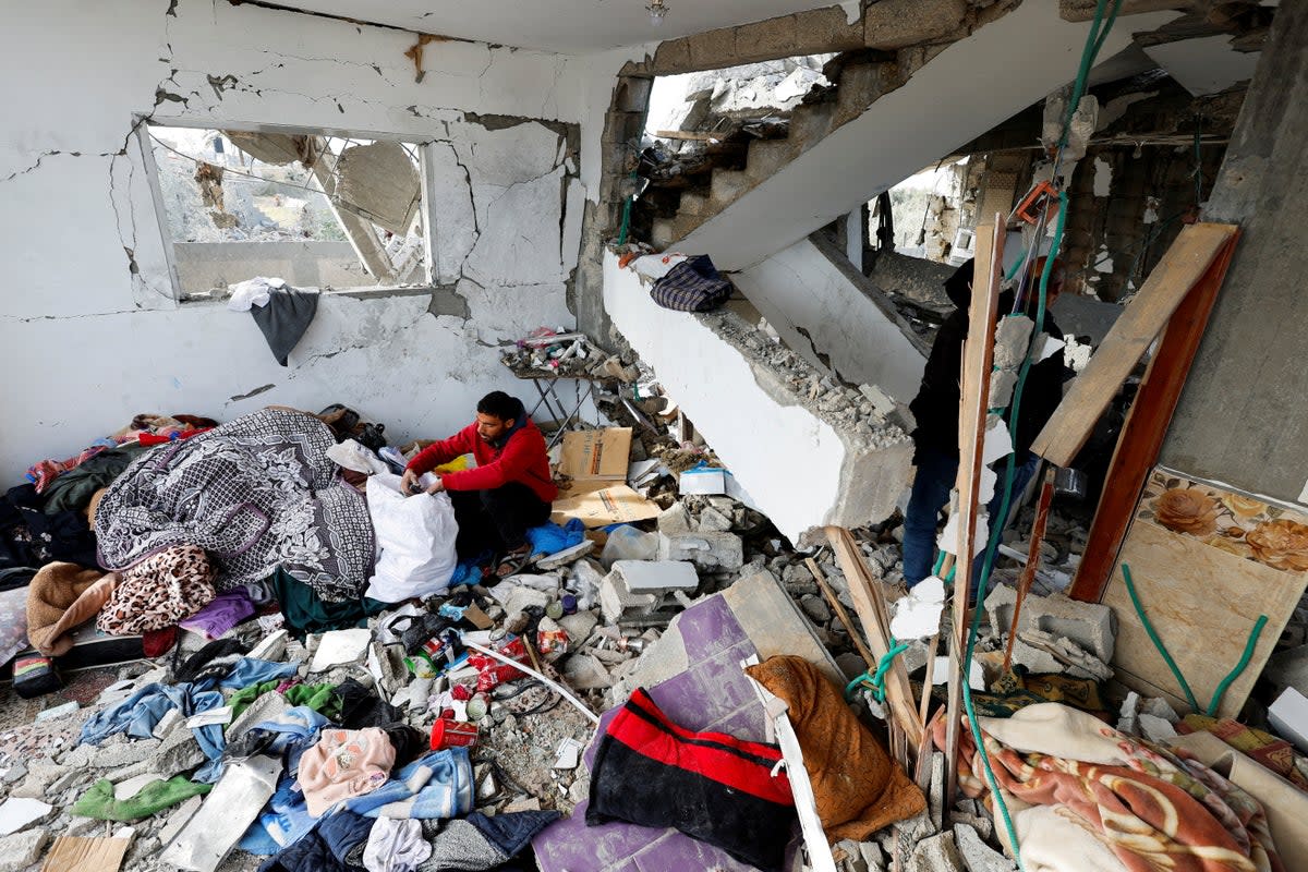 A Palestinian man retrieves belongings from the site of an Israeli strike on a house, in Rafah, southern Gaza (Reuters)