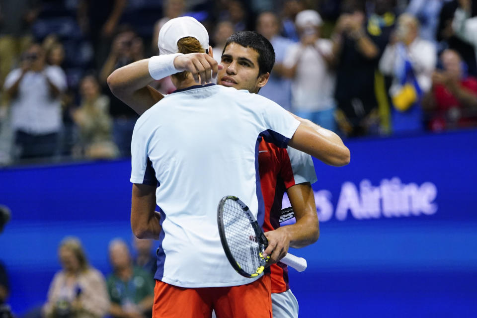 Carlos Alcaraz, of Spain, right, hugs Jannik Sinner, of Italy, after Alcaraz won their match in the quarterfinals of the U.S. Open tennis championships, early Thursday, Sept. 8, 2022, in New York. (AP Photo/Frank Franklin II)