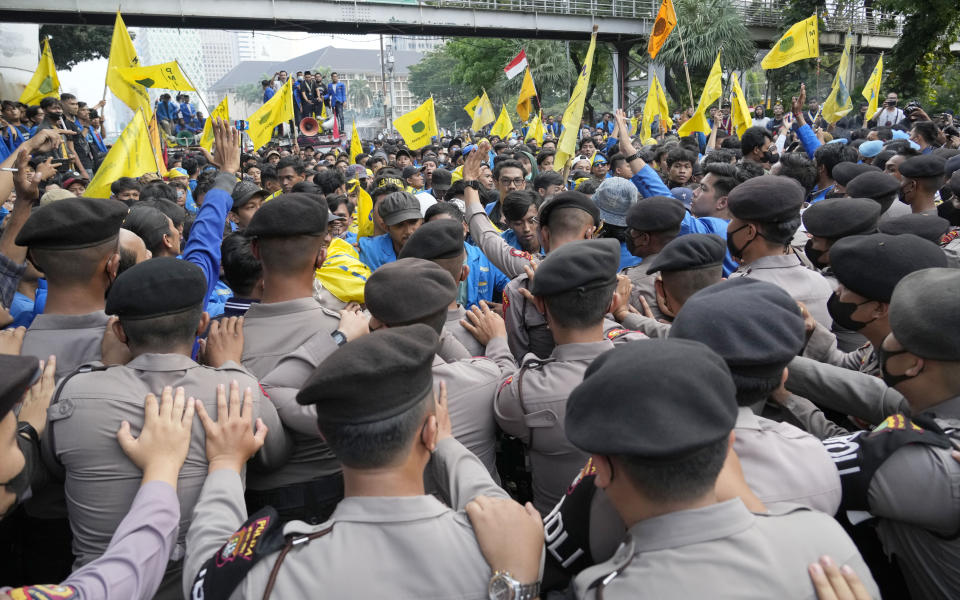 Police officers push back students during a rally against fuel price hikes in Jakarta, Indonesia, Monday, Sept. 5, 2022. Fuel prices increased by about 30 percent across Indonesia on Saturday after the government reduced some of the costly subsidies that have kept inflation in Southeast Asia's largest economy among the world's lowest. (AP Photo/Tatan Syuflana)