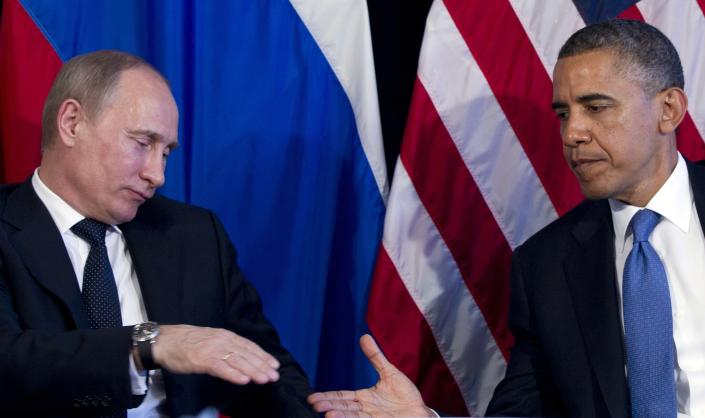 ロシアとアメリカの国旗の前で握手する直前のプーチンとオバマ。