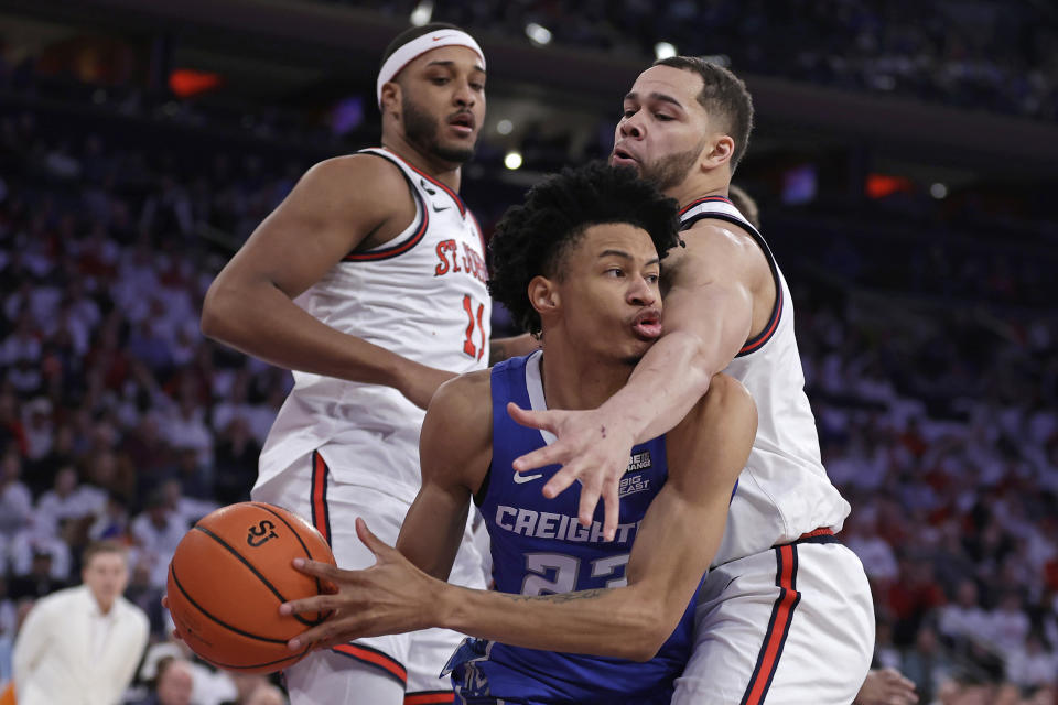 Creighton guard Trey Alexander (23) looks to pass around St. John's guard Chris Ledlum during the first half of an NCAA college basketball game Sunday, Feb. 25, 2024, in New York. (AP Photo/Adam Hunger)