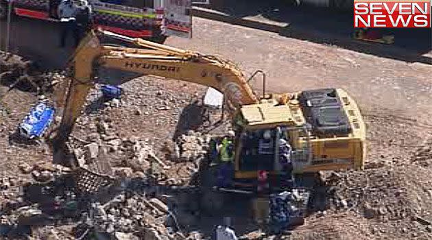 Paramedics work to free the 19-year-old man who had been working on a townhouse development on Sydney's north shore. Photo: 7News