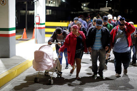 People belonging to a caravan of migrants from Honduras en route to the United States, walk at the border crossing to Mexico in Hidalgo, Mexico, January 18, 2019. REUTERS/Jose Cabezas