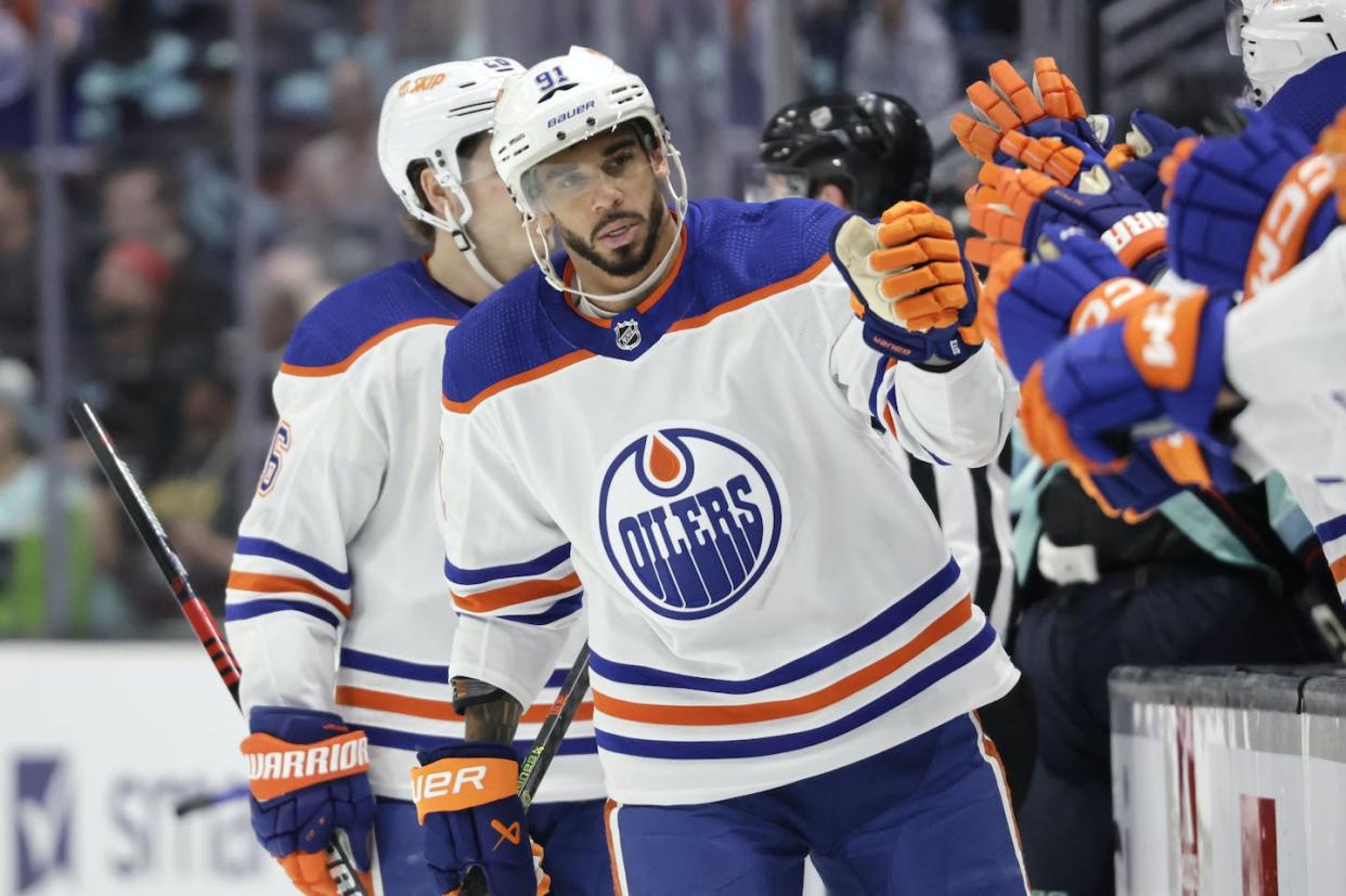 Edmonton Oilers left wing Evander Kane is congratulated after scoring his third goal against the Seattle Kraken during the third period of an NHL hockey game on March 18, 2023, in Seattle. (AP Photo/John Froschauer)