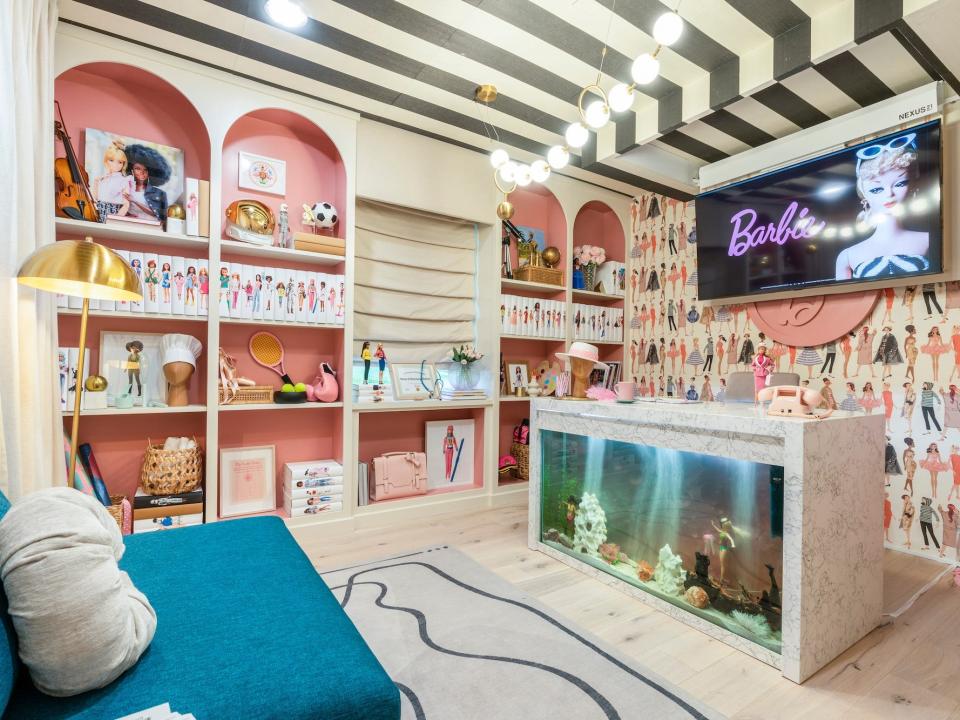 A room with built-in shelving, striped walls, and fun furniture.