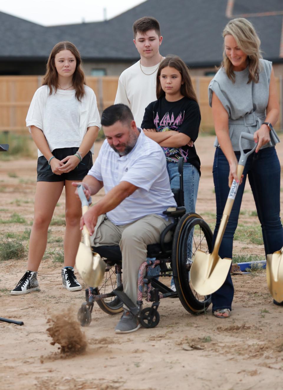 Jason Lilley turns a shovel of soil during a ground breaking ceremony. Behind him is his family, from left, 17-uear-old Mackenzie, 18-year-old Austin, 12-year-old Madison and his wife Michelle Lilley. West Texas Hero Homes held a ground breaking ceremony in Wolfforth Monday, Sept. 25, 2023, to build a home for U.S. Marine Corps Sergeant Jason Lilley and his family.