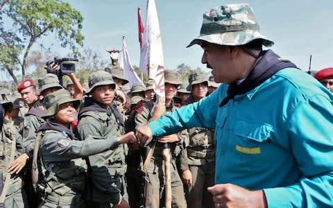 Venezuela's President Nicolas Maduro (R) greeting troop members during military exercises on May 4 - Credit: AFP