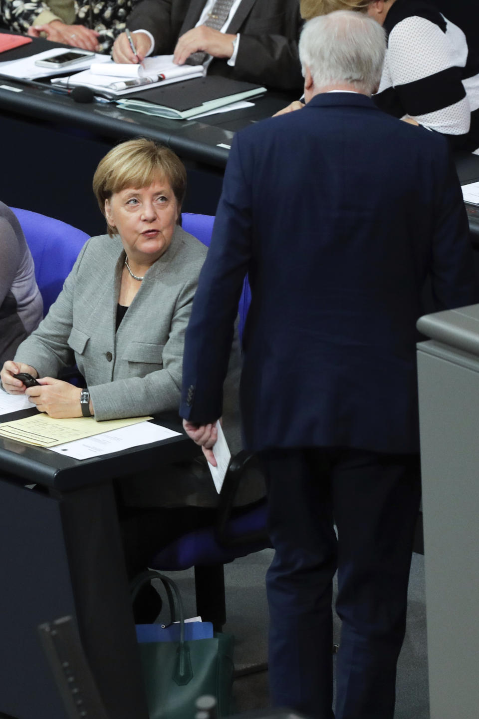 German Chancellor Angela Merkel, left, talks to Interior Minister Horst Seehofer after his speech during a plenary session of the German parliament Bundestag about the budget 2019, in Berlin, Thursday, Sept. 13, 2018. (AP Photo/Markus Schreiber)