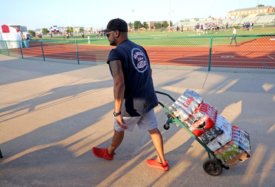 Matthew David brings drinks to the band booster concession stand at the high school football game between Shawnee and Carl Albert at Crain Family Stadium on the Oklahoma Baptist University campus in Shawnee, Okla., Thursday, Sept. 28, 2023.