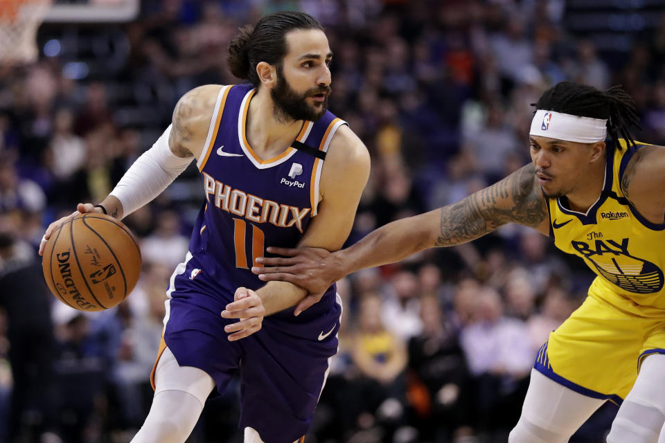 FILE - In this Feb. 29, 2020, file photo, Phoenix Suns guard Ricky Rubio (11) drives as Golden State Warriors guard Damion Lee (1) defends during the second half of an NBA basketball game in Phoenix. The Minnesota Timberwolves reached an agreement to bring back Rubio on a busy Wednesday night, Nov. 18, 2020. The Timberwolves, according to a person with knowledge of the negotiations, plan to send the 17th pick to the Oklahoma City Thunder for the 25th and 28th overall selections and Rubio. (AP Photo/Matt York, File)