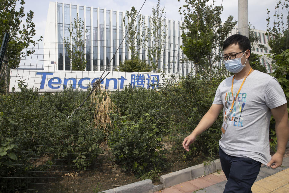 A man walks past the Tencent headquarters in Beijing, China on Friday, Aug. 7, 2020. President Donald Trump on Thursday ordered a sweeping but unspecified ban on dealings with the Chinese owners of consumer apps TikTok and WeChat, although it remains unclear if he has the legal authority to actually ban the apps from the U.S. WeChat is owned by Chinese company Tencent. (AP Photo/Ng Han Guan)