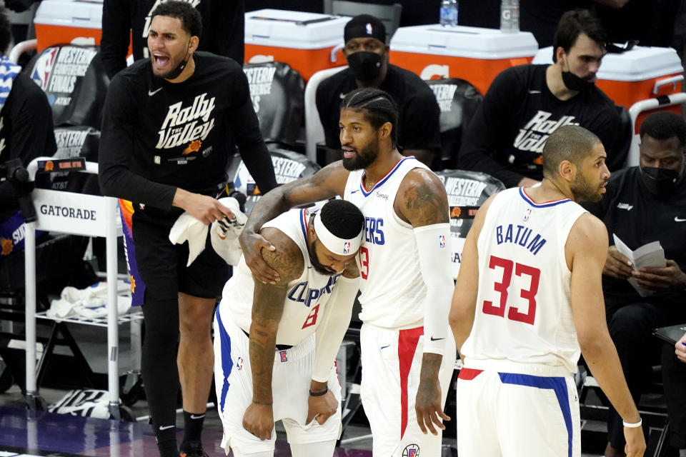 Los Angeles Clippers guard Paul George embraces Los Angeles Clippers forward Marcus Morris Sr., left, after a foul against the Phoenix Suns during the first half of game 5 of the NBA basketball Western Conference Finals, Monday, June 28, 2021, in Phoenix. (AP Photo/Matt York)