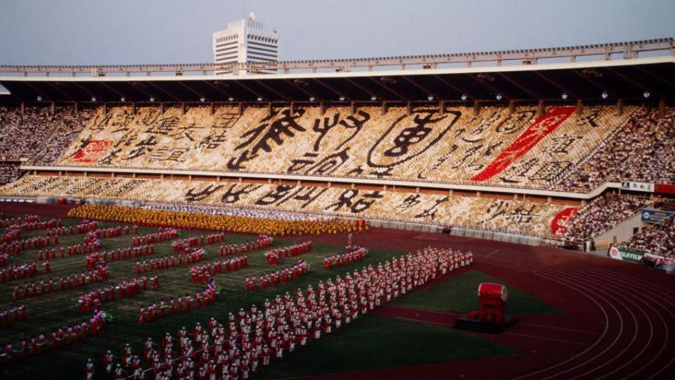 Beijing's Workers' Stadium with fans holding up signs and dancers on the stadium floor to mark the opening of the Asian Games